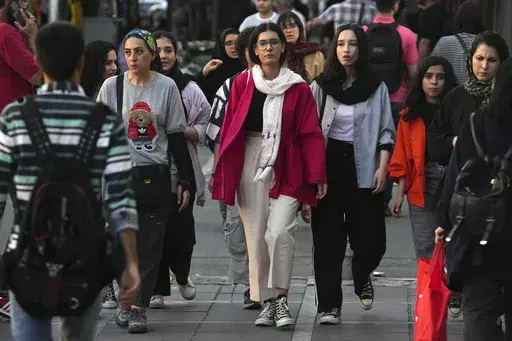 Iranian women, some without wearing their mandatory Islamic headscarves, walk in downtown Tehran, Iran, Saturday, Sept. 9, 2023. Iran's parliament on Wednesday, Sept. 20, 2023, approved a bill to impose heavier penalties on women who refuse to wear the mandatory Islamic headscarf in public and those who support them. The move came just days after the anniversary of the death of Mahsa Amini, a 22-year-old woman who had been detained by the morality police for violating the country's dress code. (
