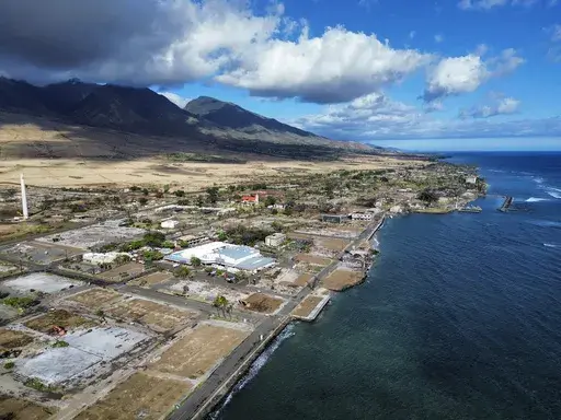 A general view of Front Street shows the primary debris from last year's wildfire being removed from commercial properties, Wednesday, June 26, 2024, in Lahaina, Hawaii. (AP Photo/Mengshin Lin)