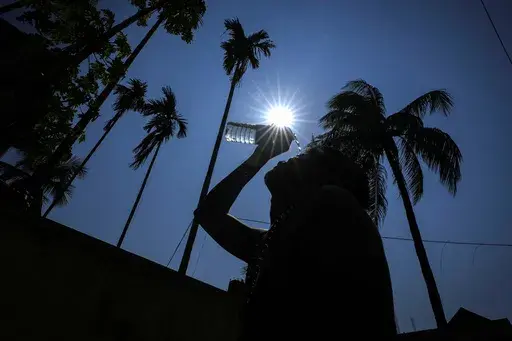 A man pours water on his face to cool off on a hot summer day in Guwahati, India, Saturday, May 25, 2024. Month after month, global temperatures are setting new records. (AP Photo/Anupam Nath, File)
