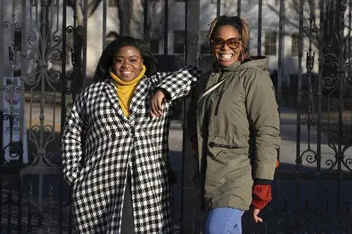 Chassity Coston, left, and Charity Wallace pose outside Harvard Yard at Harvard University, Saturday, Feb. 24, 2024, in Cambridge, Mass. With attacks on diversity, equity and inclusion initiatives raging on, Black women looking to climb the work ladder are seeing a landscape that looks more hostile than ever. (AP Photo/Michael Dwyer)