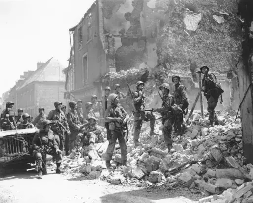 U.S. soldiers stand on the remains of a house as they inspect damage in Carentan, in the Normandy region of France, June 15, 1944. The 80th anniversary this week of D-Day is a mixed bag of emotions for French survivors of the Battle of Normandy. They remain eternally grateful for their liberation from Nazi occupation in World War II but cannot forget its steep cost in French lives. (AP Photo/Peter Carroll, File)