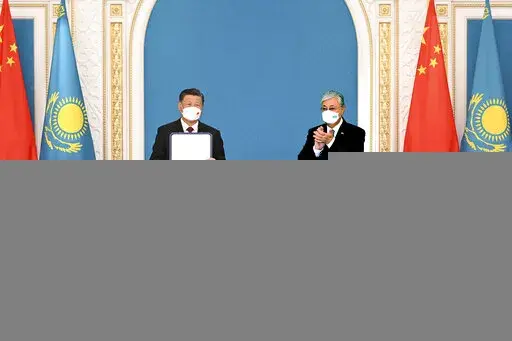 In this photo released by Xinhua News Agency, Chinese President Xi Jinping, left, receives the Order of the Golden Eagle, or "Altyn Qyran" Order, awarded by Kazakhstan's President Kassym-Jomart Tokayev at the Ak Orda Presidential Palace in Nur-Sultan, Kazakhstan, Wednesday, Sept. 14, 2022. (Rao Aimin/Xinhua via AP)