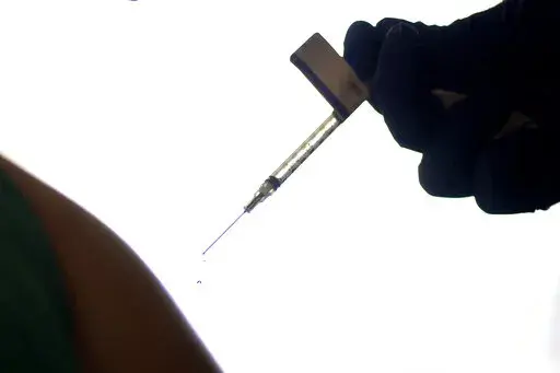 A droplet falls from a syringe after a health care worker was injected with the Pfizer-BioNTech COVID-19 vaccine at Women & Infants Hospital in Providence, R.I., on Dec. 15, 2020. On Friday, June 10, 2022, The Associated Press reported on stories circulating online incorrectly claiming that 20,000 people have died from COVID-19 vaccines. The figure misrepresents data maintained by the Centers for Disease Control and Prevention and the Food and Drug Administration. To date, a total of nine deaths