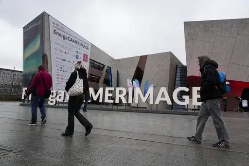 People walk in front of the venue of the 32nd Camerimage International Film Festival in Torun, Poland, Wednesday, Nov. 20, 2024. (AP Photo/Czarek Sokolowski)