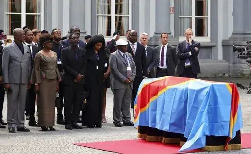 The children of Patrice Lumumba, from left, Roland, Juliana and Francois, stand next to the casket with the mortal remains of Patrice Lumumba during a ceremony at the Egmont Palace in Brussels, Monday, June 20, 2022. On Monday, more than sixty one years after his death, the mortal remains of Congo's first democratically elected prime minister Patrice Lumumba were handed over to his children during an official ceremony in Belgium. (AP Photo/Olivier Matthys)