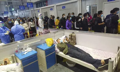 People who have been negative in the last two nucleic acid tests line up to leave a temporary hospital converted from the National Exhibition and Convention Center to quarantine COVID-positive people in Shanghai, China on April 18, 2022. Interviews with family members of people testing positive for COVID-19, a phone call with a government health official and an independent tally raise questions about how Shanghai calculates virus cases and deaths, almost certainly resulting in a marked undercoun
