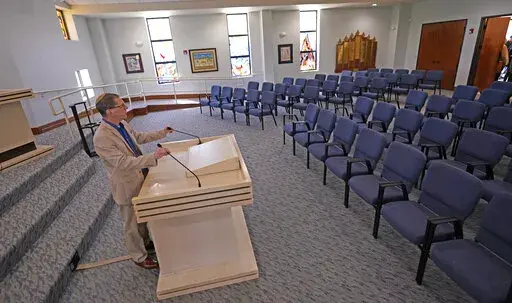 Rabbi Charlie Cytron-Walker adjusts the microphones while testing the sound system at Congregation Beth Israel in Colleyville, Texas, Thursday, April 7, 2022. Three months after an armed captor took hostages at the Texas synagogue during a 10-hour standoff that ended with the escape of the hostages and fatal shooting of the gunman by the FBI, the house of worship is reopening. (AP Photo/LM Otero)