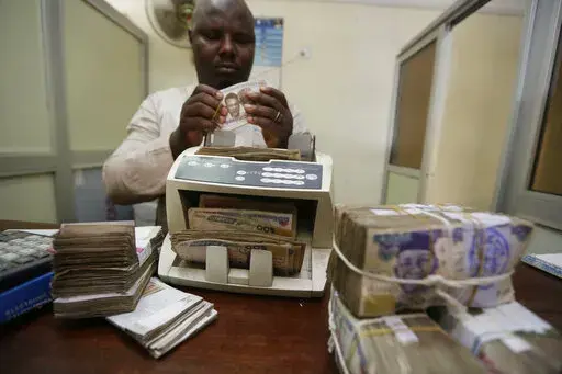 A money changer counts Nigerian naira currency at a bureau de change, in Lagos Nigeria, Oct. 20, 2015. Nigeria's push to replace the local currency notes with newly designed ones is creating an economic crisis, experts warned Monday, Jan. 30, 2023 with the limited cash in circulation hurting many people and businesses across the West African nation. (AP Photo/Sunday Alamba, File)