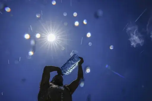A man pours cold water onto his head to cool off on a sweltering hot day in the Mediterranean Sea in Beirut, Lebanon, Sunday, July 16, 2023. In the past 30 days, nearly 5,000 heat and rainfall records have been broken or tied in the United States and more than 10,000 records set globally, according to the National Oceanic and Atmospheric Administration. Since 2000, the U.S. is setting about twice as many heat records as cold. (AP Photo/Hassan Ammar, File)