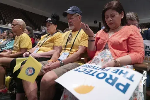 People pray before the start of the Moms for Liberty National Summit in Washington, Saturday, Aug. 31, 2024. (AP Photo/Jose Luis Magana)