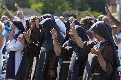 Attendees pray during a "rosary rally" on Sunday, Aug. 6, 2023, in Norwood, Ohio. As the campaigning for and against the nation’s latest tug-of-war over abortion begins in earnest this weekend, Ohio voters are getting a different message from the measure’s opponents. (AP Photo/Darron Cummings, File)