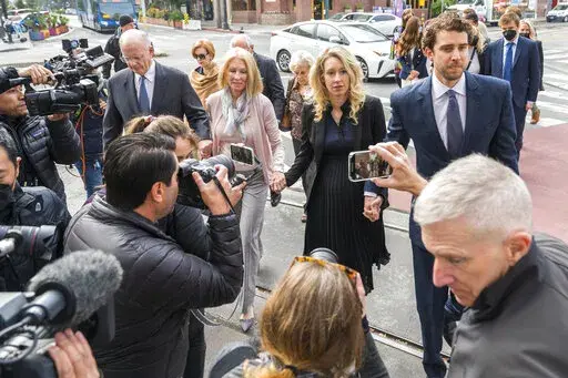 Theranos founder and CEO Elizabeth Holmes, center, walks into federal court with her partner Billy Evans, right, and her parents in San Jose, Calif., Friday, Nov. 18, 2022.  A federal judge will decide whether Holmes should serve a lengthy prison sentence for duping investors and endangering patients while peddling a bogus blood-testing technology. 
 (AP Photo/Nic Coury)