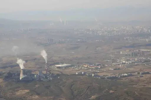 Smoke and steam rise from towers at the coal-fired Urumqi Thermal Power Plant as seen from a plane in Urumqi in western China's Xinjiang Uyghur Autonomous Region on April 21, 2021. China is promoting coal-fired power as the ruling Communist Party tries to revive a sluggish economy, prompting warnings that Beijing is setting back efforts to cut climate-changing carbon emissions from the biggest global source. (AP Photo/Mark Schiefelbein, File)