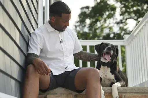 Dave Crenshaw poses for a photo with his service dog, Doc, in front of his home in Kearny, N.J., on Monday, June 3, 2024. (AP Photo/Mary Conlon)