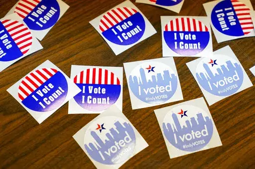 Stickers await voters during primary election voting in Indianapolis, Tuesday, May 3, 2022. (AP Photo/Michael Conroy)