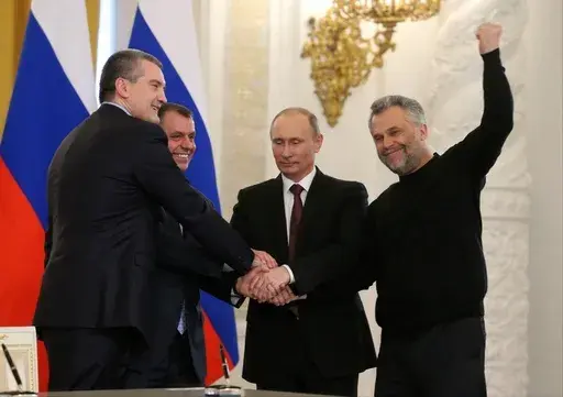 Russian President Vladimir Putin, second right, Speaker of the Crimean legislature Vladimir Konstantinov, second left, Crimean Premier Sergei Aksyonov, left, and Sevastopol Mayor Alexei Chalyi, right, shake hands after signing a treaty for Crimea to join Russia in the Kremlin in Moscow, Tuesday, March 18, 2014. Russia's quick and bloodless seizure of Ukraine's Crimean Peninsula, home to Russia's Black Sea fleet and a popular vacation site, touched off a wave of patriotism and sent Putin's popula
