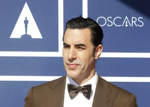 In this April 26, 2021 file photo, Sacha Baron Cohen arrives to attend a screening of the Oscars in Sydney, Australia.  Cohen has dropped his lawsuit against a Massachusetts cannabis dispensary that used an image of his character Borat on a billboard without his permission.  A document filed in Boston federal court on Tuesday, May 17, 2022, said the two sides have agreed to dismiss the case brought last year by the “Borat” star.  (AP Photo/Rick Rycroft, File)