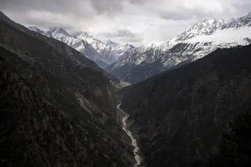 The Sutlej River flows in the valley below the tall snowy peaks in the Kinnaur district of the Himalayan state of Himachal Pradesh, India, March 13, 2023. A new report Tuesday, June 20, from a Nepal-based research organization finds that water security for nearly 2 billion people living downstream of rivers that originate in the Himalayan ranges will likely be threatened by the end of this century due to rapid glacier melt if global warming is not controlled. (AP Photo/Ashwini Bhatia, File)