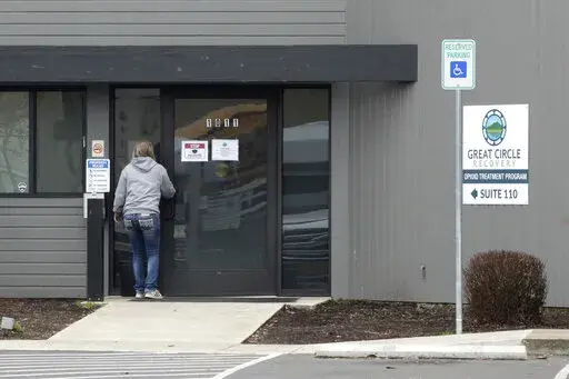 A woman enters the Great Circle drug treatment center in Salem, Ore., on March 8, 2022. Two years ago, Oregonians voted to decriminalize drugs and dedicate hundreds of millions of dollars to treatment services, but the state's first-in-the-nation drug decriminalization has had a rocky start. Secretary of State Shemia Fagan said on Thursday, Jan. 19, 2023, as she released an audit of the program that it's too early to call it a failure. (AP Photo/Andrew Selsky, File)