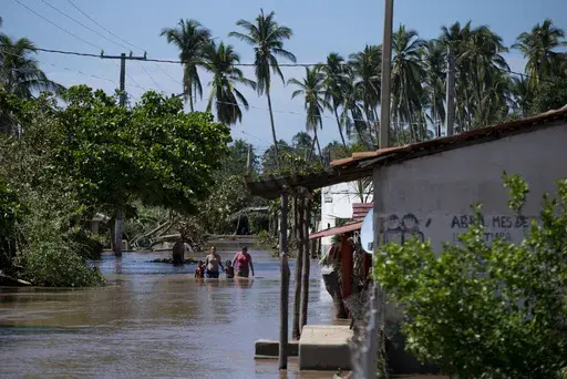 Residents wade down a street through receding floodwaters, two days after Hurricane Patricia, in the village of Rebalse, Jalisco State, Mexico, Oct. 25, 2015. A handful of powerful tropical storms in the last decade and the prospect of more to come has some experts proposing a new category of hurricanes: Category 6, which would be for storms with wind speeds of 192 miles per hour or more. (AP Photo/Rebecca Blackwell, File)