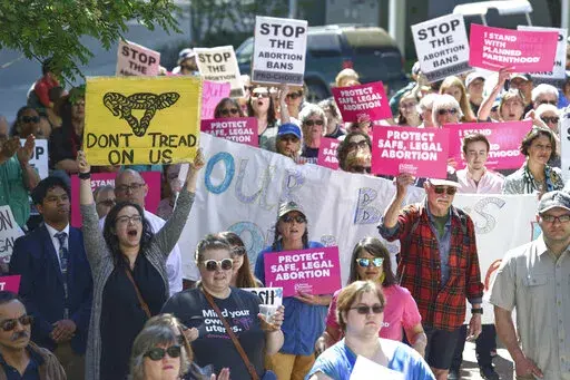 This May 21, 2019, photo shows people attending a rally against anti-abortion laws at the Dimond Courthouse Plaza in Juneau, Alaska. Alaska voters this year will be asked if they want a constitutional convention, and simmering anger over the legislature's failure to settle the issue of how big a check residents should receive from the state's oil wealth fund could provide a tail wind for groups seeking to change the constitution on a range of hot button topics, such as abortion. (Michael Penn/Th