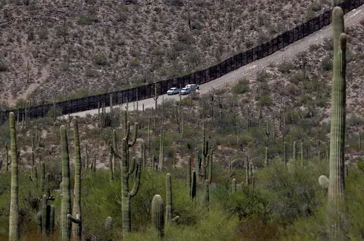 U.S. Customs and Patrol Patrol agents sit along a section of the international border wall that runs through Organ Pipe Cactus National Monument, Thursday, Aug. 22, 2019 in Lukeville, Ariz. U.S. Border Patrol agents answering reports of gunfire shot and killed a man on a tribal reservation in southern Arizona after he abruptly threw something and raised his arm, the agency said Monday, May 22, 2023. (AP Photo/Matt York, File)