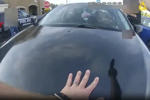 This image from bodycam video released by the Blendon Township Police on Friday, Sept. 1, 2023, shows an officer pointing his gun at Ta'Kiya Young moments before shooting her through the windshield outside a grocery store in Blendon Township, Ohio, a suburb of Columbus, on Aug. 24. The pregnant Black mother was pronounced dead shortly after the shooting. Her unborn daughter did not survive. The image was pixelated by the source. (Blendon Township Police via AP, File)