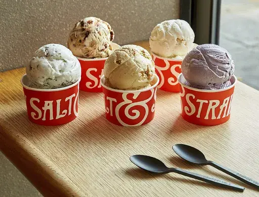This image provided by Salt & Straw shows a variety of the West Coast ice creamery's unique flavors. The company offers interesting combos like Pistachio with Saffron, and Hibiscus and Coconut. Others sound like a warm hug in gelid form: Jasmine Milk Tea laced with chocolate-coated almond slivers, or Rhubarb Crumble with Toasted Anise. (Salt & Straw via AP)