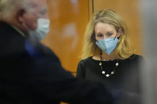 Former Theranos CEO Elizabeth Holmes walks into the Robert F. Peckham Federal Building and U.S. Courthouse for her trial in San Jose, Calif., on Tuesday, Dec. 21, 2021. (AP Photo/Tony Avelar)