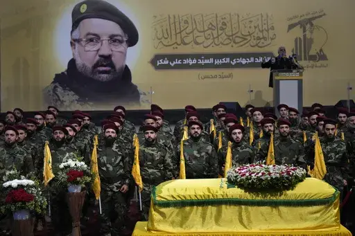 Hezbollah fighters stand behind the coffin of their top commander Fouad Shukur, who was killed by an Israeli airstrike on Tuesday, July 30, during his funeral procession in a southern suburb of Beirut, Lebanon, Aug. 1, 2024. (AP Photo/Hussein Malla)