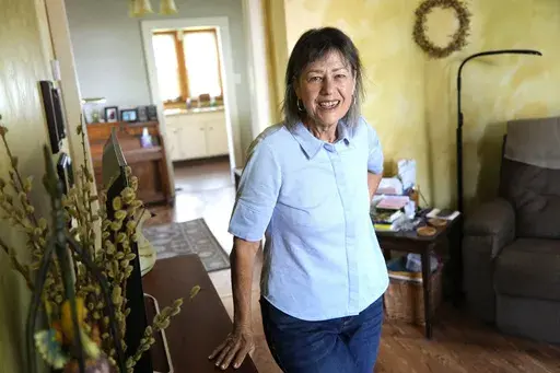 Susan Pryce stands in the living room of her Derry, Pa., home on, Saturday, May 11, 2024. A Democratic group is rolling out a new $140 million ad campaign this week that aims to chip away at Donald Trump’s support among one of his most loyal voting blocs: rural voters. Pryce, 74, a retired nurse, has offered a litany of reasons why she does not support Trump, from his comments maligning the late Sen. John McCain, a former prisoner of war, to his history of bragging about sexually abusing women