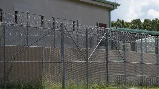 Rolls of razor wire line the top of the security fencing at the Raymond Detention Center in Raymond, Miss., Aug. 1, 2022. A man who escaped from the Mississippi jail on April 22, 2023, has been founded dead at a truck stop in New Orleans, authorities announced Tuesday, May 2. (AP Photo/Rogelio V. Solis, File)