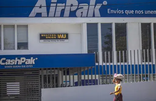 A candy vendor walks past a Western Union branch in Managua, Nicaragua, Saturday, Feb. 25, 2023. Remittances to Nicaraguans sent home in 2022 surged 50%, a jump that analysts say is directly related to the thousands of Nicaraguans who emigrated to the U.S. in the past two years.(AP Photo/Inti Ocon)