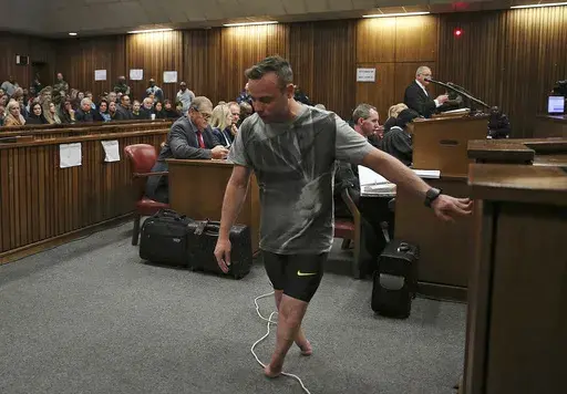 FILE — Oscar Pistorius, walks on his stumps during argument in mitigation of sentence by his defense attorney Barry Roux in the High Court in Pretoria, South Africa, Wednesday, June 15, 2016. An appeals court found Pistorius guilty of murder and not a lesser charge of culpable homicide for the shooting death of his girlfriend Reeva Steenkamp. Pistorius shot his girlfriend Reeva Steenkamp more than a decade ago in a Valentine's Day killing that jolted the world and shattered the image of a spor