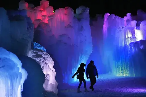 Colorful lights shine inside inside the walls of ice at Ice Castles, Friday, Jan. 10, 2025, in North Woodstock, N.H. (AP Photo/Robert F. Bukaty)