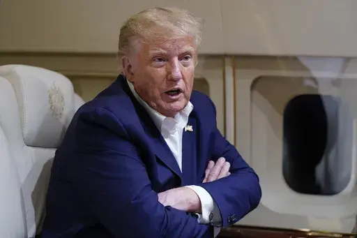 Former President Donald Trump speaks with reporters while in flight on his plane after a campaign rally at Waco Regional Airport, in Waco, Texas, March 25, 2023, while en route to West Palm Beach, Fla. (AP Photo/Evan Vucci, File)