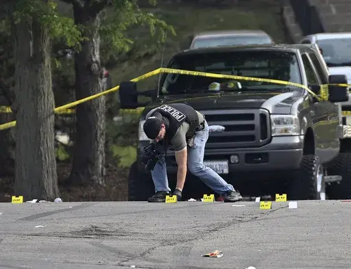 A police officer works the scene of an overnight mass shooting at a strip mall in Willowbrook, Ill., June 18, 2023. A suburban Chicago teen is facing weapons charges in connection with a June shooting where one person died and 22 others were injured, authorities said Friday, Oct. 6, 2023. (AP Photo/Matt Marton, File)