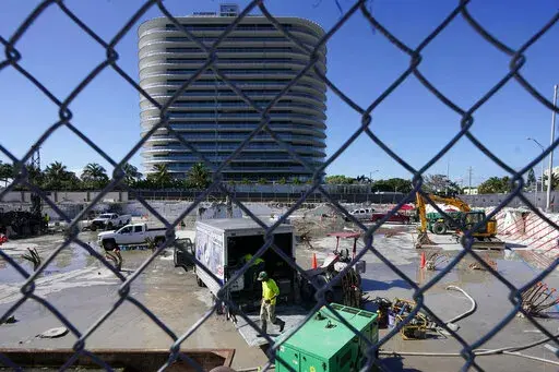 Workers pump water out of the foundation of the former Champlain Towers South building, Thursday, May 12, 2022, in Surfside, Fla. Attorneys for the families who lost relatives or homes in last year’s collapse of a Florida condominium tower that killed 98 people finalized a $1 billion settlement on Friday, May 27, 2022. (AP Photo/Marta Lavandier, File)