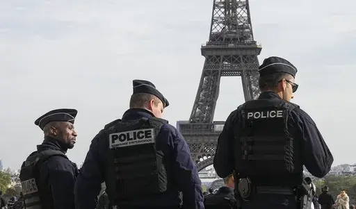 Police officers patrol the Trocadero plaza near the Eiffel Tower in Paris, Tuesday, Oct. 17, 2023. Police have arrested a man climbing on the Eiffel Tower. The drama temporarily stranded a crowd at the top. Among those trapped was a Washington, D.C., couple who decided during the wait to get married and an Associated Press reporter who got their story. Amir Khan had been planning to propose to Kate Warren later Thursday in a Paris garden away from the crowds, with a romantic dinner on the River 