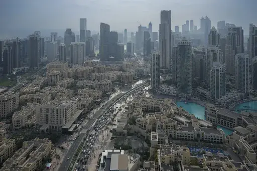 Vehicles ply at a slow pace through a street with Dubai's iconic skyline in the background, United Arab Emirates, on Dec. 31, 2024. (AP Photo/Altaf Qadri)