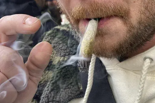 A man smokes marijuana in lower Manhattan outside the first legal dispensary for recreational marijuana in New York on Thursday, Dec. 29, 2022. Daily and near-daily marijuana use is now more common than similar levels of high-frequency drinking in the U.S., according to an analysis of survey data over four decades, according to research published Wednesday, May 22, 2024, in the journal Addiction. (AP Photo/Ted Shaffrey, File)