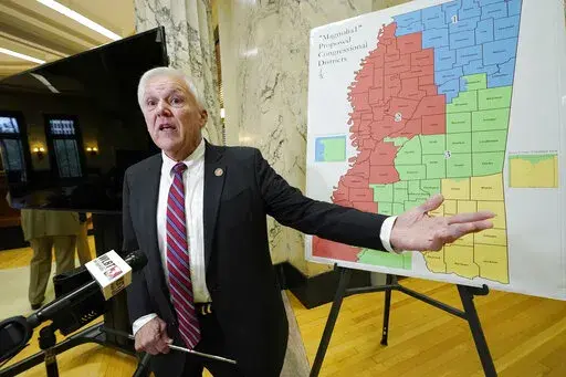 Joint Congressional Redistricting and Legislative Reapportionment Committees chairman Rep. Jim Beckett, R-Bruce, stands before a poster of the "Magnolia 1" proposed congressional plan, and explains the process involved in determining the congressional boundaries following the meeting at the Capitol, during which the committees approved its final proposal for Congressional redistricting, Wednesday, Dec. 15, 2021, in Jackson, Miss. (AP Photo/Rogelio V. Solis)