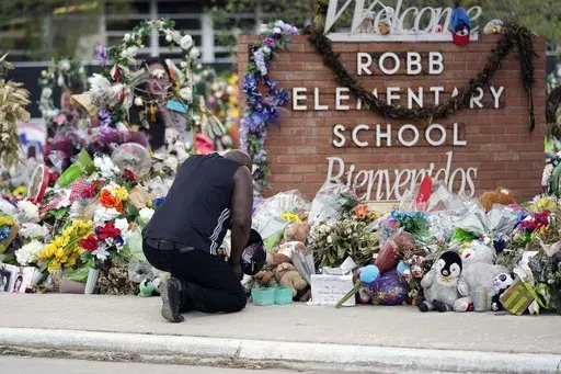 Reggie Daniels pays his respects a memorial at Robb Elementary School, Thursday, June 9, 2022, in Uvalde, Texas. The 19 fourth-graders and two teachers killed at the elementary school are being remembered, Friday, May 24, 2024 as the second anniversary of the one of the deadliest school shootings in U.S. history is marked. (AP Photo/Eric Gay)