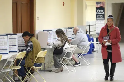 A woman walks with her ballot to a vacant voting booth at City Hall in San Francisco, March 5, 2024. (AP Photo/Eric Risberg, File)