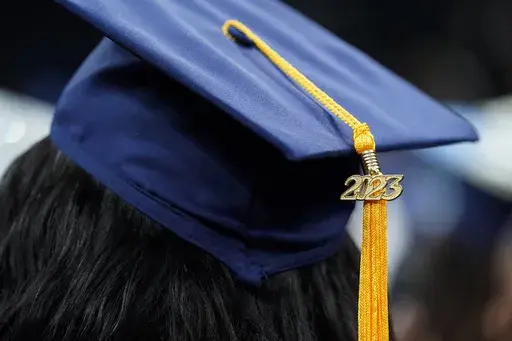 A tassel with 2023 on it rests on a graduation cap as students walk in a procession for Howard University's commencement in Washington, Saturday, May 13, 2023. The Supreme Court is getting ready to decide some of its biggest cases of the term, including the fate of President Joe Biden’s plan to wipe away or reduce student loans held by millions of Americans. (AP Photo/Alex Brandon, File)