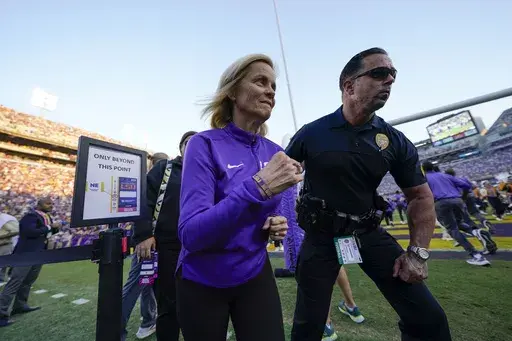 LSU national champion women's basketball head coach Kim Mulkey runs on the sideline before an NCAA college football game against Auburn in Baton Rouge, La., Saturday, Oct. 14, 2023. (AP Photo/Gerald Herbert)