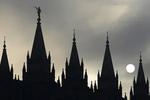 The angel Moroni statue atop the Salt Lake Temple is silhouetted against a cloud-covered sky, at Temple Square in Salt Lake City on Feb. 6, 2013. The U.S. Securities and Exchange Commission says, Tuesday, Feb. 21, 2023, The Church of Jesus Christ of Latter-day Saints and its investment arm will pay $5 million in fines. The SEC alleges the church used shell companies to obscure the size of the portfolio under the church's control.(AP Photo/Rick Bowmer, File)