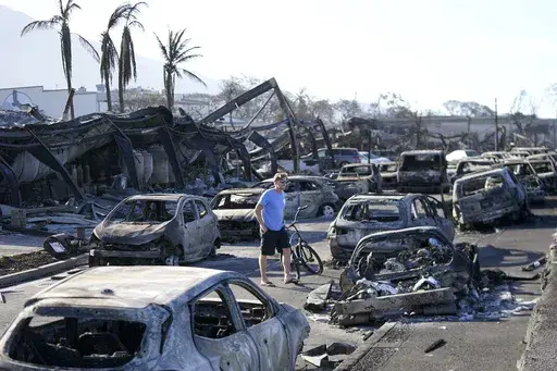 A man walks through wildfire wreckage in Lahaina, Hawaii, Aug. 11, 2023. Federal authorities have started removing hazardous materials from the Maui wildfires and laying the groundwork to dispose of burnt cars, buildings and other debris. The hazardous materials, including oil, solvent and batteries, are being shipped to the West Coast while the U.S. Army Corps of Engineers works with local officials to develop a plan to dispose of an estimated 400,000 to 700,000 tons of debris on the island. (A
