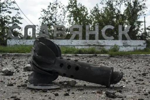 A part of the mortar shell is seen in front of a sign that reads 'Slovyansk', after heavy fighting between pro-Russian fighters and Ukrainian government troops just outside Slovyansk, eastern Ukraine, Wednesday, July 9, 2014. The eastern Ukrainian city of Slovyansk was occupied by pro-Russian separatists for months in 2014. Now its people are preparing to defend their community again as the fighting draws closer and invites a major battle. Slovyansk is a city of splintered loyalties, with some r