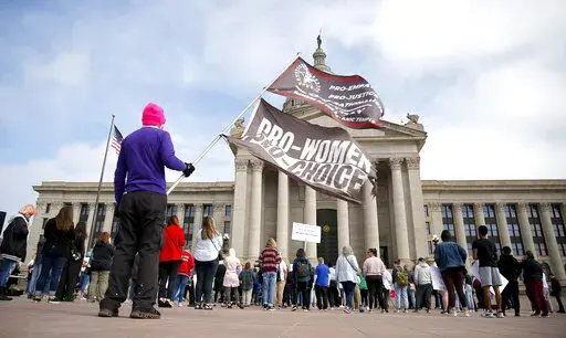 A person holds flags during the Bans Off Oklahoma Rally on the steps on Oklahoma state Capitol in Oklahoma City, Tuesday, April, 5, 2022. The Oklahoma House has given final approval to a Texas-style abortion ban that prohibits abortion after about six weeks of pregnancy. The bill passed Thursday, April 28, 2022, by the GOP-led House now heads to Republican Gov. Kevin Stitt, who is expected to sign it within days. (Sarah Phipps/The Oklahoman via AP, File)
